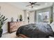 This main bedroom features a rustic wood dresser, ceiling fan, and view of outdoor courtyard at 6353 N Fulton St, Denver, CO 80238