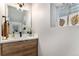 Bright bathroom features wood vanity with modern sink, sleek fixtures, and unique decor at 3580 W 62Nd Pl, Denver, CO 80221