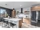 Bright modern kitchen featuring a large island, stainless steel appliances, and wood-look cabinets at 3580 W 62Nd Pl, Denver, CO 80221