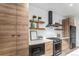 Stylish kitchen with wood cabinets, stainless steel appliances, and floating shelves with decor at 3580 W 62Nd Pl, Denver, CO 80221