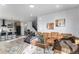 Open-concept living area with hardwood floors, tan sofa, dining area, and modern kitchen at 3580 W 62Nd Pl, Denver, CO 80221