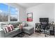 Cozy office space featuring a gray couch, modern desk, and a large window for natural light at 3580 W 62Nd Pl, Denver, CO 80221