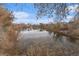 Picturesque pond reflecting the sky and surrounding trees, creating a serene natural setting at 3580 W 62Nd Pl, Denver, CO 80221