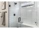 Stylish tiled shower with glass door and modern fixtures at 3580 W 62Nd Pl, Denver, CO 80221