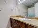 Functional bathroom featuring a single sink vanity with wood cabinets and a framed mirror above at 3518 S Depew St # 102, Lakewood, CO 80235