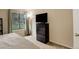 Bright bedroom featuring natural light from the window, complemented by a chest of drawers and mounted TV at 3518 S Depew St # 102, Lakewood, CO 80235