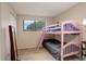bedroom with pink bunk beds next to a window and full length mirror offering a fun and functional space at 3518 S Depew St # 102, Lakewood, CO 80235