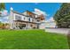Large backyard featuring green grass, an outdoor kitchen, and an entertainment area for Gathering and friends at 4520 W Moncrieff Pl, Denver, CO 80212