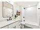 Elegant bathroom boasts a modern vanity, stylish fixtures, and a pristine white tiled shower/tub combo at 4520 W Moncrieff Pl, Denver, CO 80212