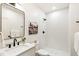 Elegant bathroom with a modern vanity, black fixtures, and a pristine white tiled shower, creating a luxurious feel at 4520 W Moncrieff Pl, Denver, CO 80212