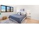 Bright bedroom features a large window, modern decor, and a comfortable bed with stylish pillows at 4520 W Moncrieff Pl, Denver, CO 80212