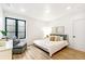 Inviting bedroom features hardwood floors, a cozy bed, and a comfortable seating area, perfect for relaxation at 4520 W Moncrieff Pl, Denver, CO 80212