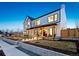 Stunning two-story home with a covered porch and warm exterior lighting at 4520 W Moncrieff Pl, Denver, CO 80212