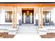 Charming front porch with concrete steps and covered entryway with wood accents at 4520 W Moncrieff Pl, Denver, CO 80212