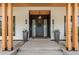Elegant front porch featuring wood accents, stylish lighting, and decorative planters at 4520 W Moncrieff Pl, Denver, CO 80212