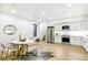 Modern kitchen and dining area features stainless steel appliances, white cabinetry, and stylish dining set at 4520 W Moncrieff Pl, Denver, CO 80212