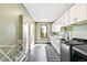 Well-lit laundry room with modern appliances, ample cabinet space, and sleek tile flooring at 4520 W Moncrieff Pl, Denver, CO 80212
