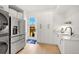 Bright laundry room with stainless steel appliances, sink, and ample storage at 4520 W Moncrieff Pl, Denver, CO 80212