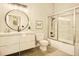 A modern bathroom with sleek vanity, round mirror, and a tiled shower at 1140 Columbine St # 106, Denver, CO 80206