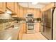 Close-up of kitchen features including stainless steel appliances, tile backsplash, sink and countertops at 1140 Columbine St # 106, Denver, CO 80206