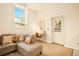 Well-lit living room featuring a comfortable sofa, a work desk, and a door leading to the outside at 1140 Columbine St # 106, Denver, CO 80206