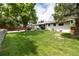 Spacious backyard with green lawn, patio, and exterior view of the home at 3400 S Ivy Way, Denver, CO 80222