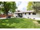 Expansive backyard features well-maintained lawn and a covered patio, perfect for outdoor enjoyment and entertaining at 3400 S Ivy Way, Denver, CO 80222