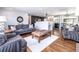 Inviting living room with hardwood floors, a cozy rug, and stylish furniture, flowing into a modern kitchen at 3400 S Ivy Way, Denver, CO 80222