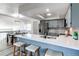 Bright kitchen featuring a white quartz countertop, stainless steel appliances, and stylish stools at the breakfast bar at 18874 E Mexico Dr, Aurora, CO 80017