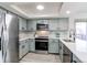 Well-lit kitchen with stainless steel appliances, and gray tile backsplash complemented by light gray cabinets at 18874 E Mexico Dr, Aurora, CO 80017