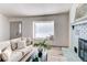 Warm and inviting living room features a large window, a stylish sofa, and a cozy fireplace at 18874 E Mexico Dr, Aurora, CO 80017