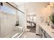 Bright bathroom showcasing marble tile, glass-enclosed shower, and vanity with neutral color palette leading to the bedroom at 1871 Grayside Cir, Castle Rock, CO 80109