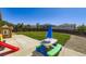 Well-kept backyard includes a covered patio with a play area and manicured lawn at 5280 Raritan Way, Denver, CO 80221