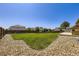 Large, landscaped backyard with a lush lawn, complemented by decorative stones and a patio area at 5280 Raritan Way, Denver, CO 80221