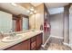 Bright bathroom featuring a double vanity, tile floors, and shower with curtain at 5280 Raritan Way, Denver, CO 80221