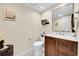 Powder bathroom with a dark wood vanity, a white sink, and stylish decor at 4146 S Mobile Cir # A, Aurora, CO 80013