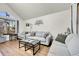 Bright living room features a vaulted ceiling, light gray sofas, and modern decor at 4146 S Mobile Cir # A, Aurora, CO 80013