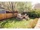 Backyard sitting area featuring wooden furniture, a stone patio, and grass at 7382 E 8Th Pl, Denver, CO 80230