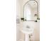 Bathroom featuring a pedestal sink, modern faucet, and decorative mirror at 7382 E 8Th Pl, Denver, CO 80230