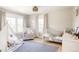 Bright Bedroom with a crib, chair, teepee, wood floors, and natural light at 7382 E 8Th Pl, Denver, CO 80230