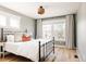 Bright bedroom featuring natural light, wood floors, and a wrought iron bed with stylish bedding at 7382 E 8Th Pl, Denver, CO 80230