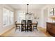 Bright dining room with a wooden table, black chairs, modern chandelier, and decorative wall art at 7382 E 8Th Pl, Denver, CO 80230