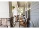 Inviting front porch features stone columns, wood railings, comfortable seating, and a hanging plant, perfect for relaxing at 7382 E 8Th Pl, Denver, CO 80230