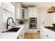 Close-up view of kitchen highlighting sink, quartz countertops, and stainless steel appliances at 7382 E 8Th Pl, Denver, CO 80230