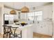 Bright kitchen with white cabinets, stainless steel appliances, island with seating and pendant lighting at 7382 E 8Th Pl, Denver, CO 80230