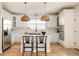 Bright kitchen with modern appliances, white cabinetry, island, pendant lighting, and hardwood floors at 7382 E 8Th Pl, Denver, CO 80230