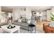 Open-concept living area with hardwood floors, comfortable seating, and a view into the kitchen at 7382 E 8Th Pl, Denver, CO 80230