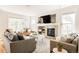 Sunlit living room with plush sofas, stylish decor, a granite fireplace, and large windows at 7382 E 8Th Pl, Denver, CO 80230
