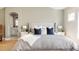 Well-lit main bedroom with a large bed, stylish decor, and a peek into the en-suite bathroom at 7382 E 8Th Pl, Denver, CO 80230