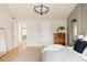 Bright main bedroom with a modern light fixture, natural wood floors, and neutral color palette at 7382 E 8Th Pl, Denver, CO 80230